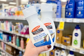 hand holding two palmers cocoa butter lotions