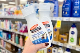 hand holding two palmers cocoa butter lotions