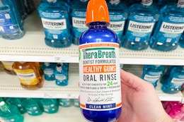 Person holding TheraBreath Mouthwash in store