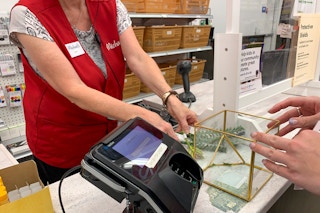 A Michaels employee ringing up purchases at the checkout.