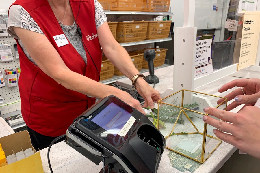 A Michaels employee ringing up purchases at the checkout.