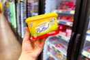 hand holding a tub of i can't believe it's not butter at dollar general