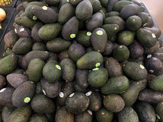 pile of avocados in walmart product section