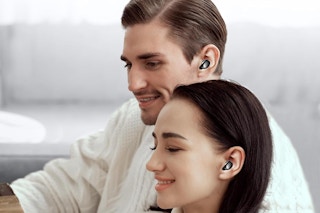 a man and woman sitting with earbuds