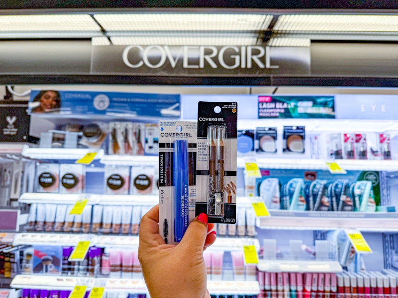 person holding covergirl mascara and eyeliner in front of the display