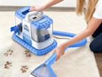 a person cleaner a carpet with a carpet cleaner
