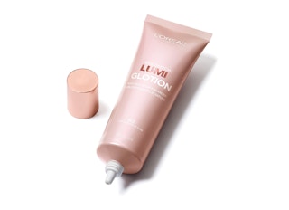 A bottle of L'Oreal Lumi Glotion on a white background