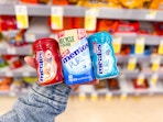 hand holding mentos gum varieties in walgreens