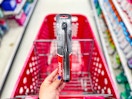 hand holding a colgate 360 electric toothbrush in front of a target cart