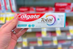 hand holding colgate total toothpaste