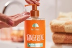 a woman using tree hut tangerine soap