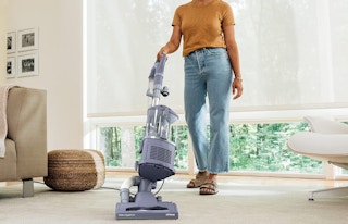 a woman vacuuming carpet in a room