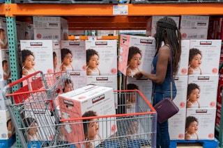 A woman shopping for Kirkland diapers inside Costco.