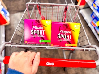 hand pushing a cvs shopping cart with playtex tampons