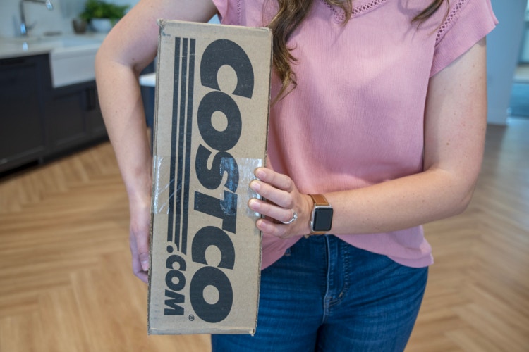 A person holding a Costco.com online order box.