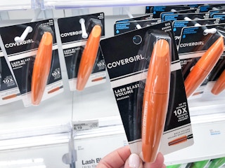 hand holding Covergirl Lashblast mascara in front of shelf
