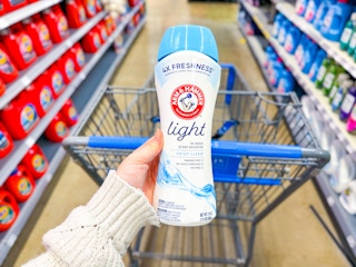 Arm & Hammer Scent Booster (Light) held over Walmart shopping cart in center aisle of laundry products