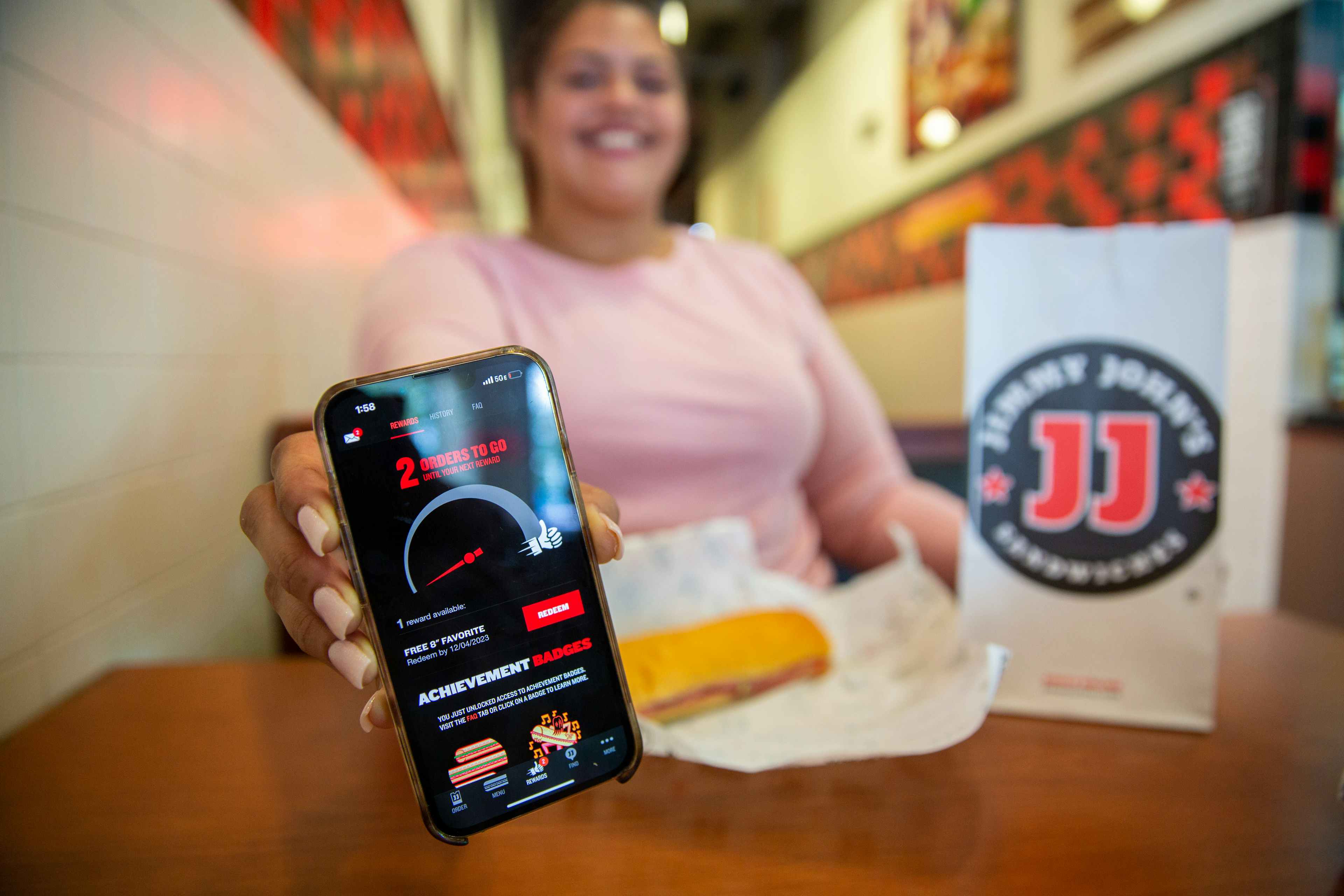 a person holding a cellphone in jimmy johns