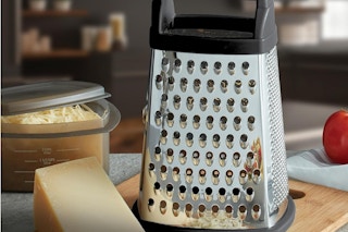 a kitchenaid grater next to a cup