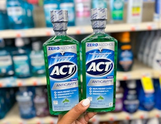 person holding two ACT mouthwashes
