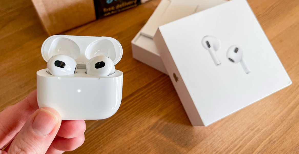 apple air pod pro being held next to amazon box