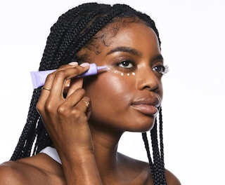 a woman putting on eye cream