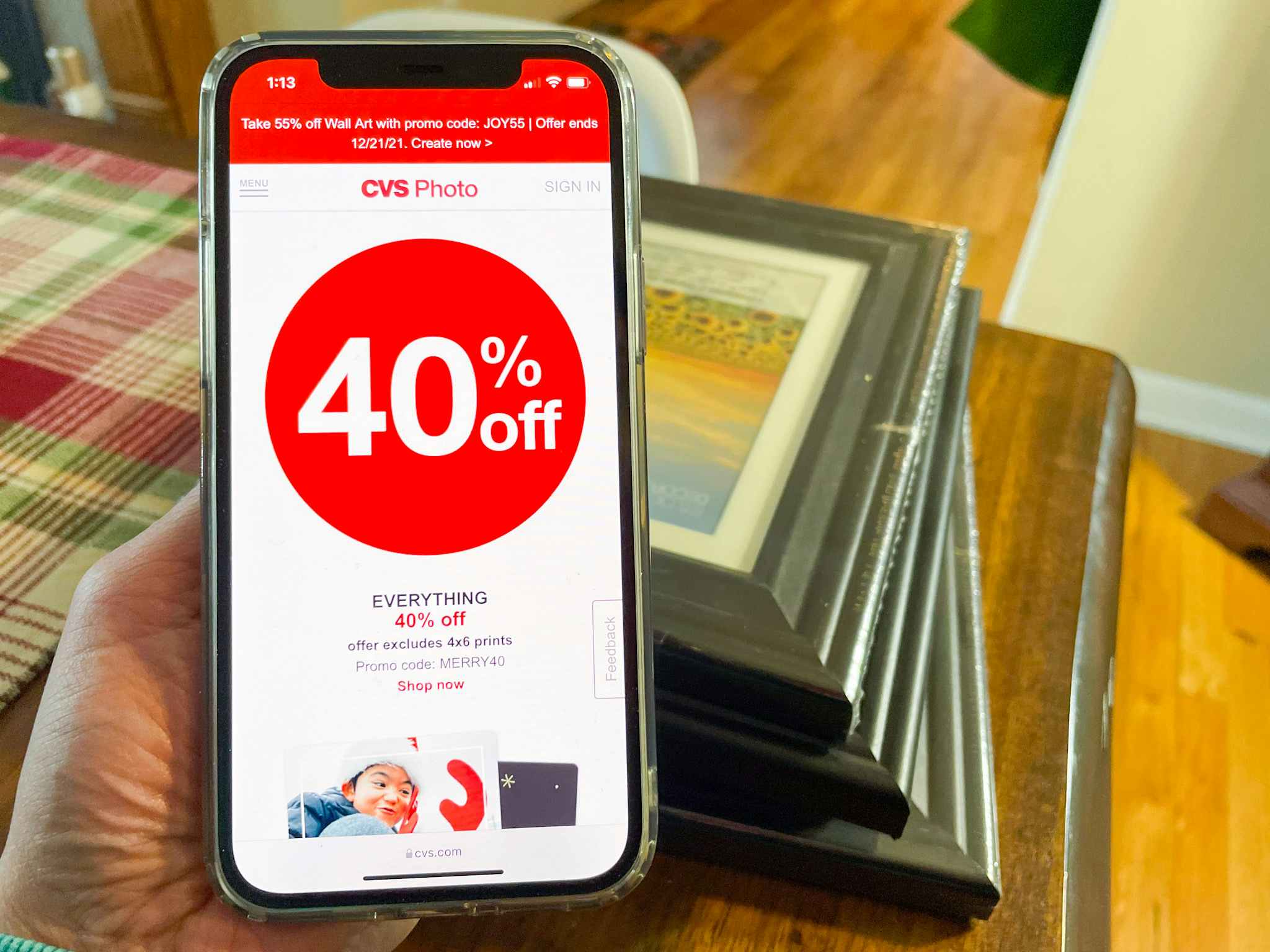 CVS photo coupon codes pulled up on a phone near picture frames