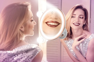 A woman using a lighted makeup mirror
