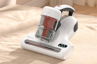 A mattress vacuum cleaner sits on a bed