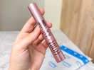 hand holding Maybelline sky hight mascara over Prime bag