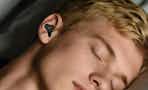 man wearing earplugs while sleeping