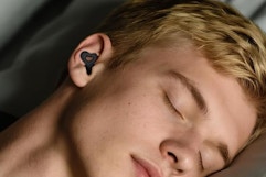man wearing earplugs while sleeping