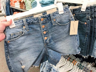 hand holding denim shorts on hanger at Target