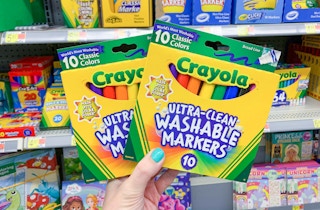 two boxes of crayola ultra-clean washable markers held up in front of makers aisle at walmart