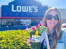 a woman holding a free flower outside Lowes for members rewards 