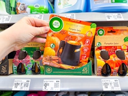 hand holding pumpkin spice air wick starter kit on walmart shelf