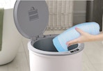 hand putting a towel in the towel warmer bucket