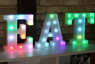 Neon colorful letters spelling EAT on a shelf