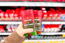 person holding old spice deodorant in front of the shelf