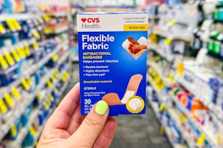 person holding a box of bandages in an aisle