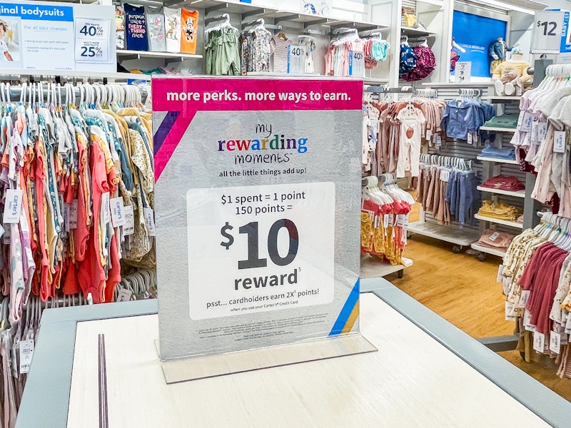 A sign for the Carter's My Rewarding Moments program advertising an offer of $10 for points earned through purchases.