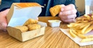 someone sitting in mcdonalds with six-piece chicken mcnuggets, honey mustard, and fries