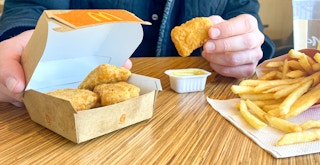 someone sitting in mcdonalds with six-piece chicken mcnuggets, honey mustard, and fries