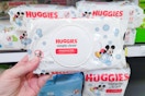 hand holding a pack of huggies baby wipes