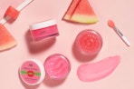 jars of pink lip mask and scrubs next to slices of watermelon