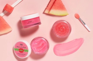 jars of pink lip mask and scrubs next to slices of watermelon