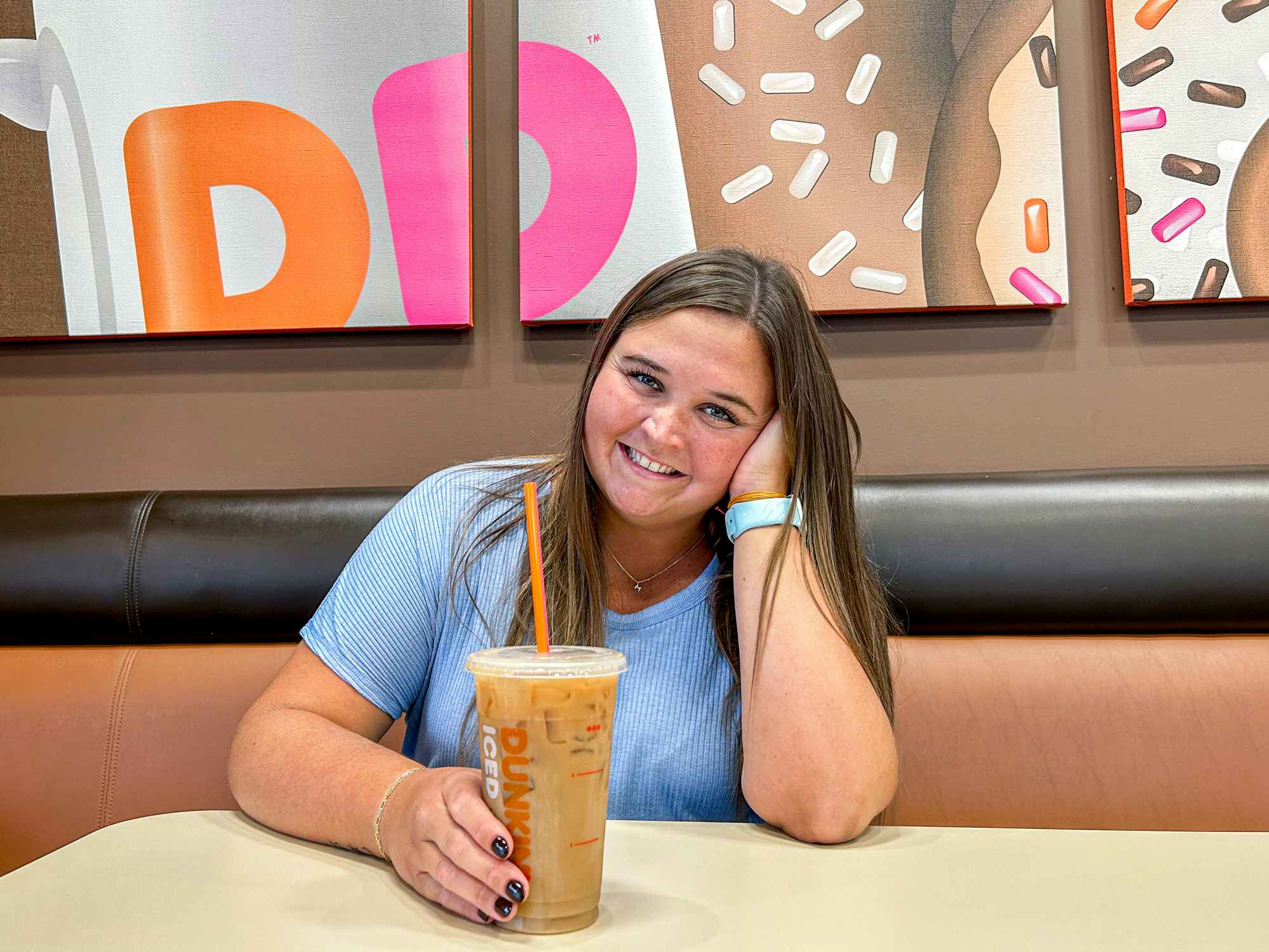 a person smiling with coffee inside of dunkin