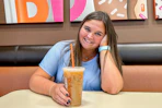 a person smiling with coffee inside of dunkin
