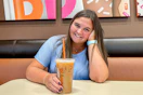 a person smiling with coffee inside of dunkin