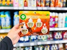 hand holding a 4 count pack of air wick refills in walmart aisle